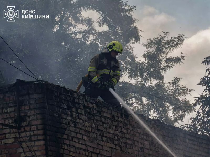 Рятувальник ДСНС Київщини ліквідує загоряння з даху цегляної будівлі.