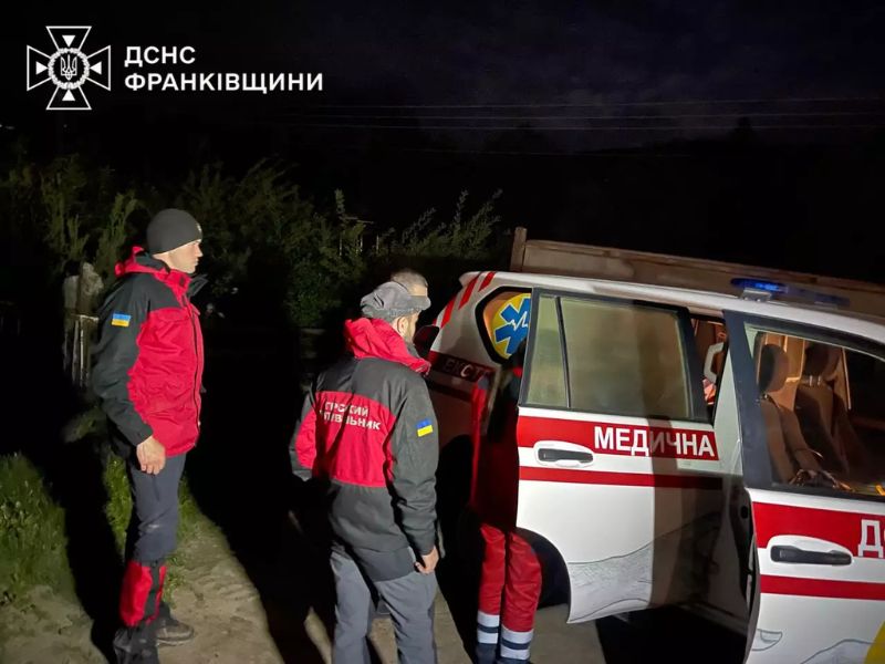 Гірські рятувальники ДСНС Івано-Франківщини передають врятовану людину бригаді екстреної медичної допомоги вночі.