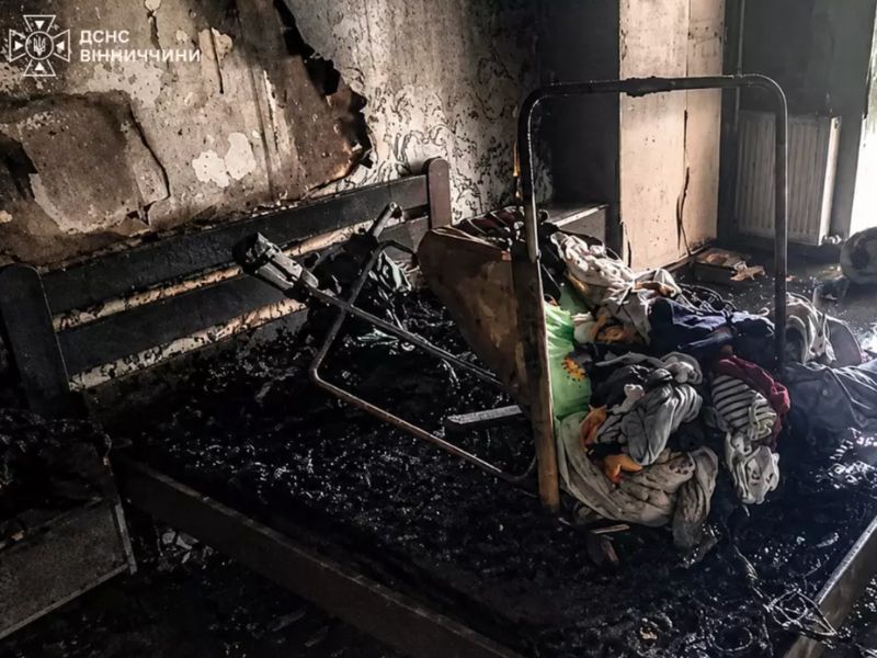 Наслідки пожежі в квартирі багатоповерхового будинку у Вінниці: згоріла кімната, обвуглені меблі та дитяча коляска після ліквідації загоряння силами ДСНС.