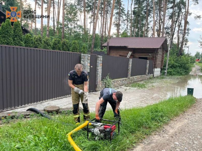 Рятувальники ДСНС використовують переносну мотопомпу для ліквідації наслідків підтоплення житлового сектору на Київщині.