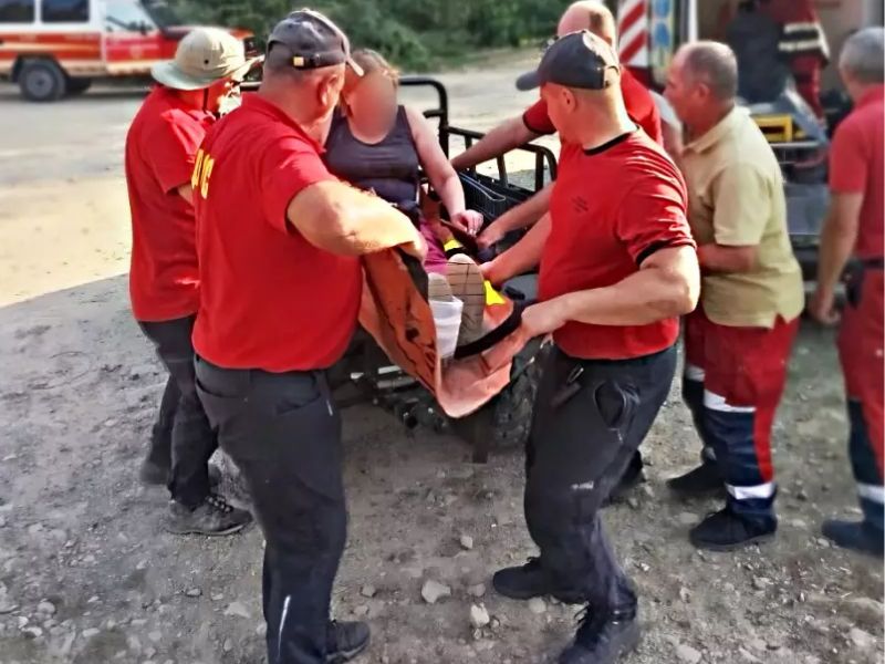 Співробітники ДСНС транспортують травмовану жінку на м'яких ношах з квадроцикла до автомобіля екстреної медичної допомоги після спуску з гір.